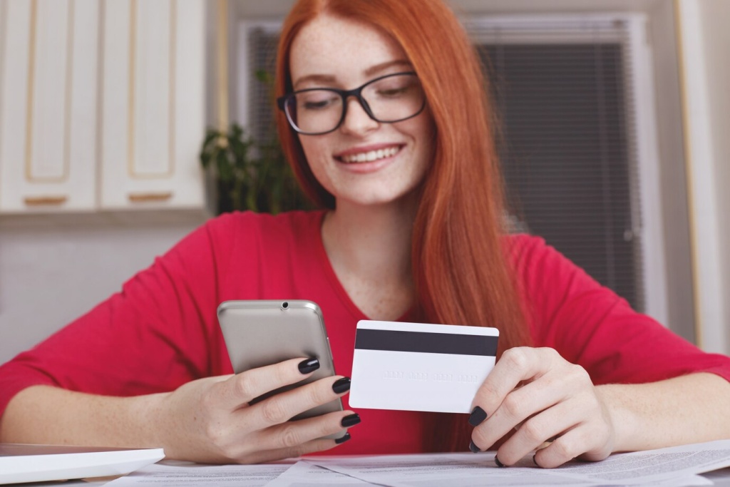 redhaired-pretty-female-model-eyewear-holds-smart-phone-credit-card_176532-7577.jpg улыбка